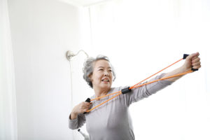 An older woman doing resistance band training