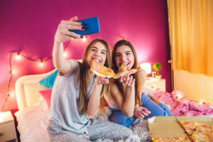 十几岁的女孩展示智能手机和不良饮食习惯