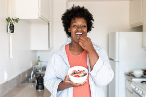 女人使用技巧来减少热量通过吃健康的早餐在厨房里