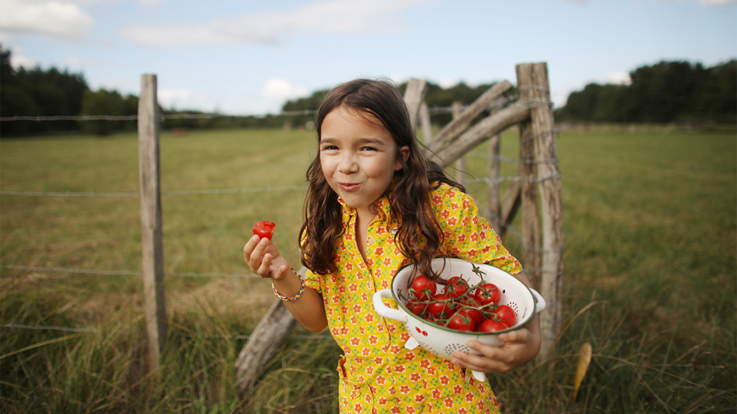 小女孩吃水果作为植物性饮食的一部分