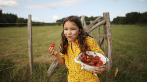 年轻女孩吃水果作为植物性饮食的一部分