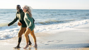 老年夫妇在海滩上演示锻炼和实际年龄