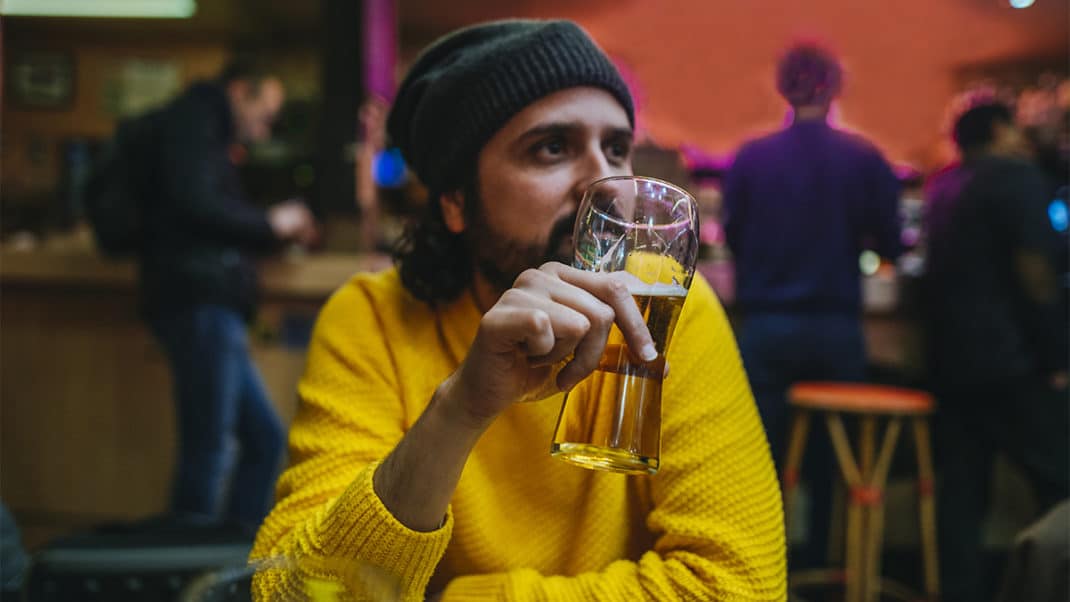 男子手持啤酒展示酒精和大脑功能之间的联系