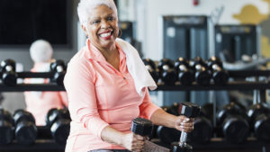 Older woman with dumbbells using muscle strengthening for longevity