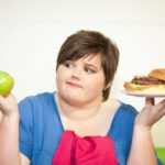 有超重的少女拿着食物代表青春期肥胖
