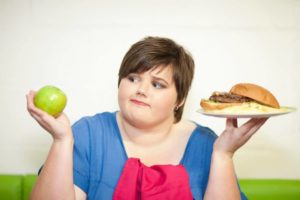 青少年超重的女孩拿着食物代表青少年肥胖