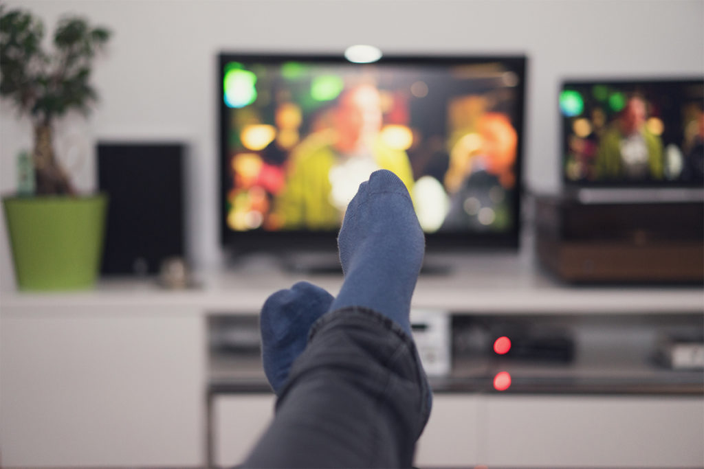 当某人懒洋洋地坐在电视机前时，可以看到他们的脚