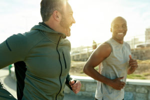 两名男子微笑着一起跑步，以表明锻炼和心理健康之间的联系