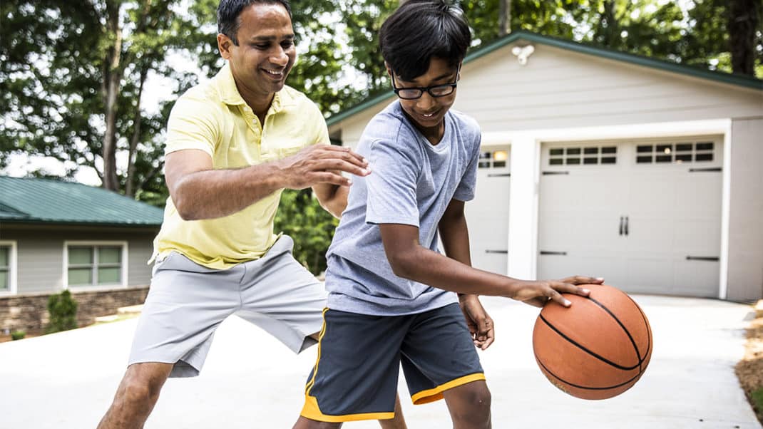 父亲和儿子一起打篮球，增加儿童活动